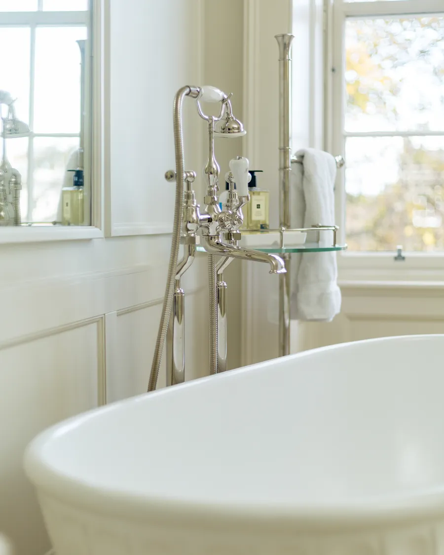 A freestanding bath with period-style bath filler in a renovated period bathroom